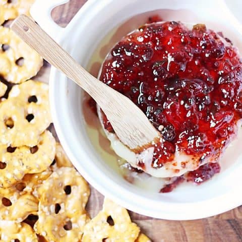 Baked Brie with Sweet Pepper Jelly -- Baked brie with sweet pepper jelly makes for the most melty, cheesy, peppery, sweet appetizer. Serve with your favorite crackers for the perfect appetizer! #brie #bakedbrie #appetizer #cheese #recipe #halfscratched #easyrecipe