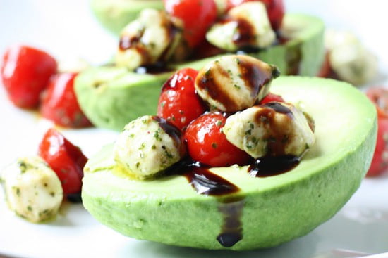 Caprese Stuffed Avocado -- Caprese stuffed avocado is one of the best ways to eat caprese salad with its creamy mozzarella, cherry tomatoes, and balsamic glaze atop ripe avocado.
