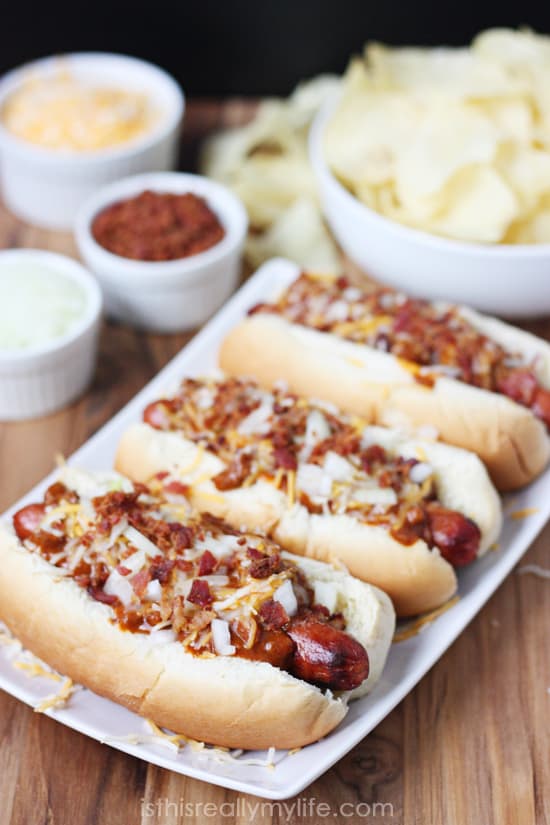 Double Bacon Chili Cheese Dog - hot dogs wrapped with bacon, grilled and topped with chili, cheese, onion and more bacon! Recipe from halfscratched.com