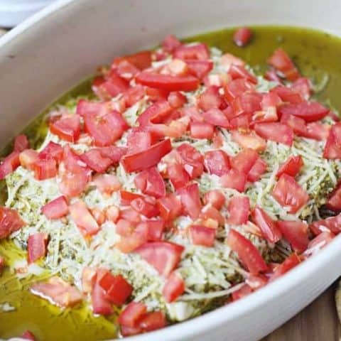 This layered pesto dip has only four ingredients and is ready in 15 minutes! Pair with your favorite crackers for the perfect hot dip! #halfscratched #appetizer #hotappetizer #easyrecipe #holidayrecipe #baking #cooking #easyappetizer #pesto #pestodip #bretoncrackers #clevergirls #ad
