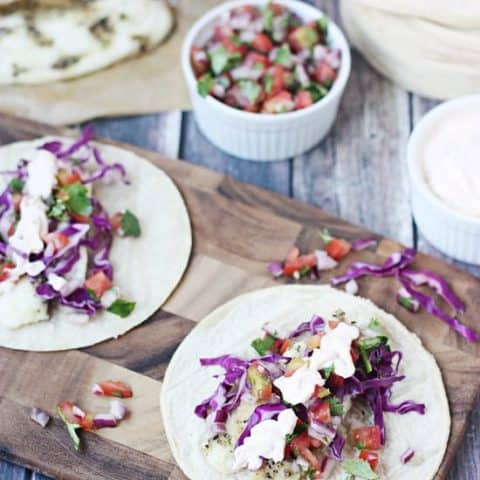 Easy Fish Tacos with Fresh Pico and Creamy Chipotle Sauce -- Ready in less than 30 minutes from start to finish! Super convenient dinner that is perfect on those crazy weeknights.
