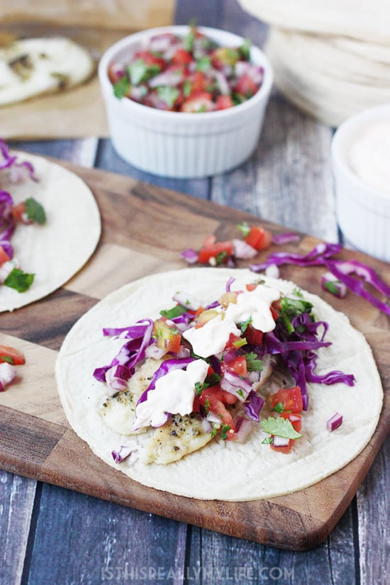Easy Fish Tacos with Fresh Pico and Creamy Chipotle Sauce -- Ready in less than 30 minutes from start to finish! Super convenient dinner that is perfect on those crazy weeknights.