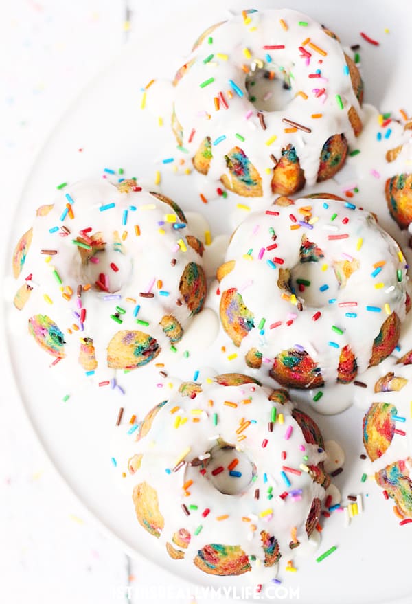 Mini Funfetti Bundt Cake with Vanilla Glaze -- Mini funfetti bundt cakes with vanilla glaze are a fun party dessert. Perfect topped with a scoop of ice cream, whipped cream, more sprinkles and a cherry! | halfscratched.com