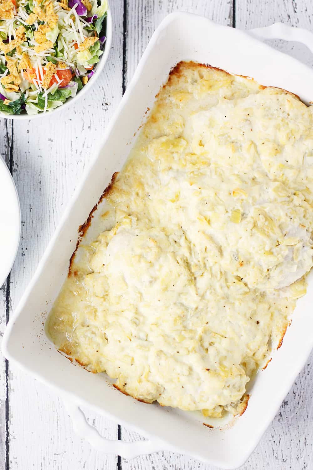 Artichoke Chicken Bake -- This artichoke chicken bake has only five ingredients, including the chicken breasts, and tastes like baked chicken smothered with hot artichoke dip. It's divine. | halfscratched #recipe #chicken