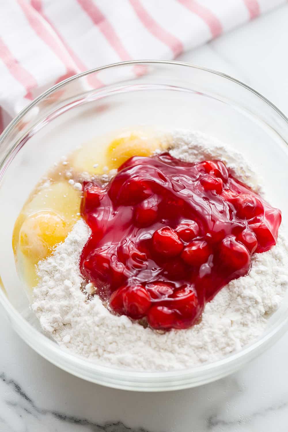 Easy Cherry Cake - Easy cherry cake with whipped topping is unbelievably delicious and requires only a white cake mix, cherry pie filling, and a few other ingredients. Whipped topping frosting is the finishing touch! #cherry #cherrycake #cakemix #cake #baking #sweets #dessert #halfscratched