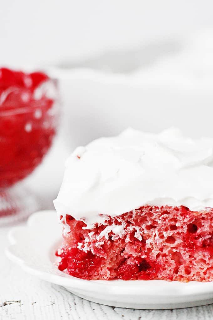 Easy Cherry Cake with Whipped Topping -- This easy cherry cake with whipped topping is unbelievably delicious and requires only a white cake mix, cherry pie filling, and three other ingredients. The whipped topping frosting is a fabulous finishing touch! | halfscratched.com #recipe #cake #valentinesday