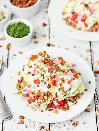 Loaded Wedge Salad -- This loaded wedge salad features iceberg lettuce topped with blue cheese dressing, red onion, tomatoes, bacon, blue cheese crumbles, and pecans. It's easier to make than you think! | halfscratched #recipe #salad