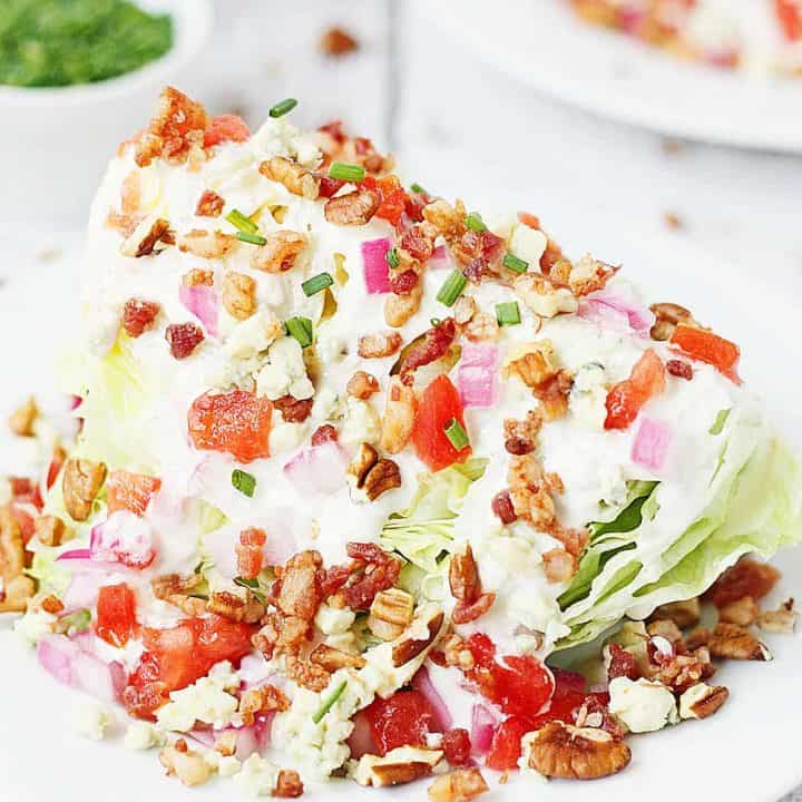 Loaded Wedge Salad -- This loaded wedge salad features iceberg lettuce topped with blue cheese dressing, red onion, tomatoes, bacon, blue cheese crumbles, and pecans. It's easier to make than you think! | halfscratched #recipe #salad