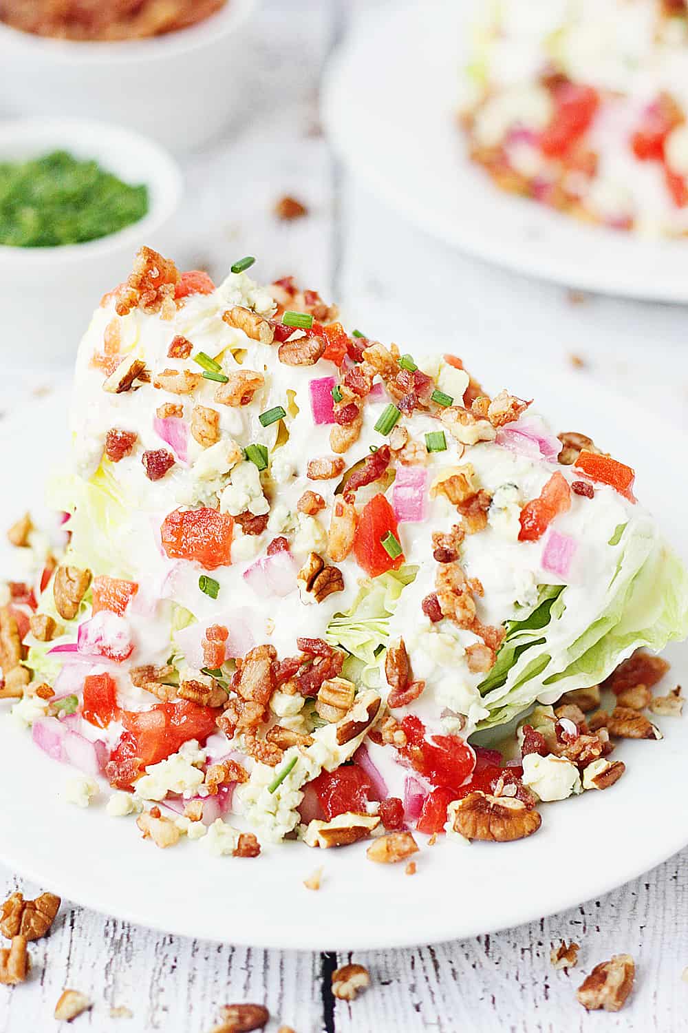 Loaded Wedge Salad -- This loaded wedge salad features iceberg lettuce topped with blue cheese dressing, red onion, tomatoes, bacon, blue cheese crumbles, and pecans. It's easier to make than you think! | halfscratched #recipe #salad