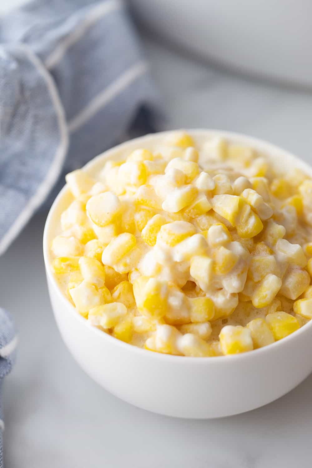 Easy Slow Cooker Creamed Corn - Ready for a side dish that's sure to please everyone? Try this easy, creamy, extra yummy slow cooker creamed corn! #creamedcorn #crockpot #slowcooker #sidedish #easyrecipe #slowcookercreamedcorn #corn #halfscratched