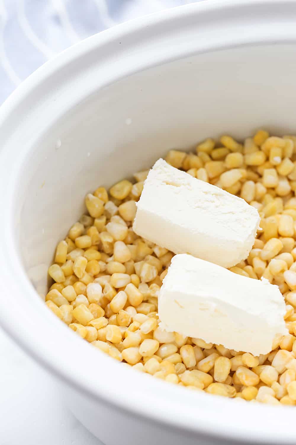 Easy Slow Cooker Creamed Corn - Ready for a side dish that's sure to please everyone? Try this easy, creamy, extra yummy slow cooker creamed corn! #creamedcorn #crockpot #slowcooker #sidedish #easyrecipe #slowcookercreamedcorn #corn #halfscratched