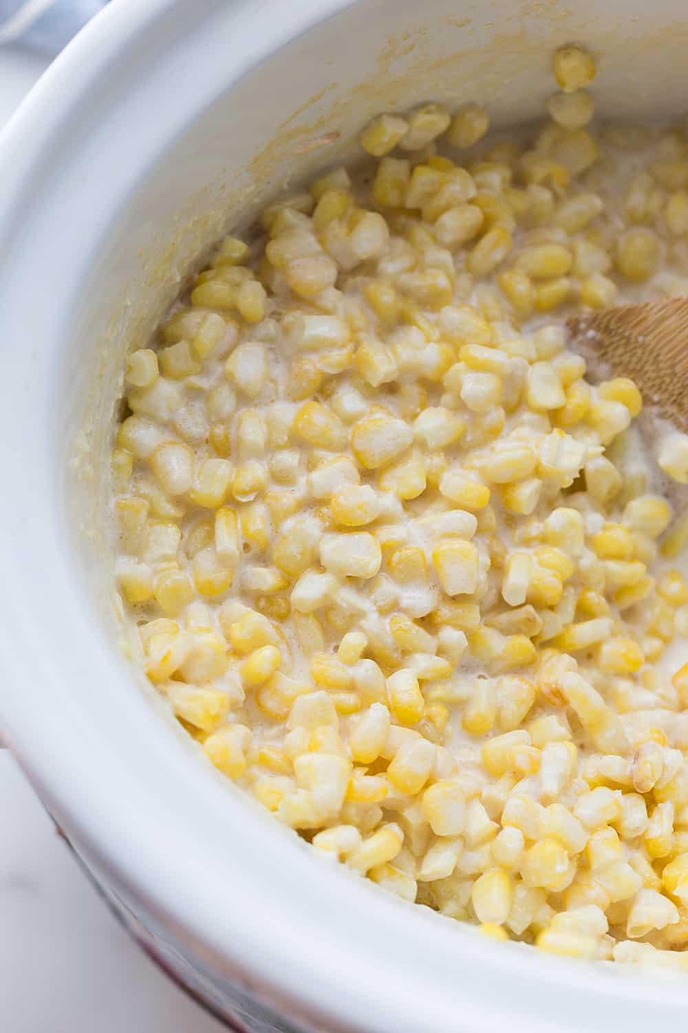 Easy Slow Cooker Creamed Corn - Ready for a side dish that's sure to please everyone? Try this easy, creamy, extra yummy slow cooker creamed corn! #creamedcorn #crockpot #slowcooker #sidedish #easyrecipe #slowcookercreamedcorn #corn #halfscratched