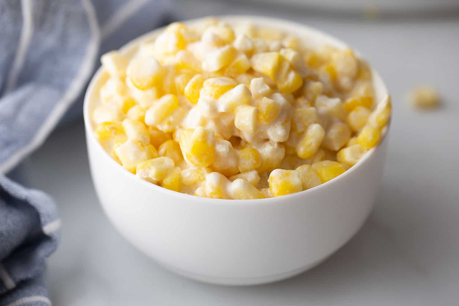 Easy Slow Cooker Creamed Corn - Ready for a side dish that's sure to please everyone? Try this easy, creamy, extra yummy slow cooker creamed corn! #creamedcorn #crockpot #slowcooker #sidedish #easyrecipe #slowcookercreamedcorn #corn #halfscratched