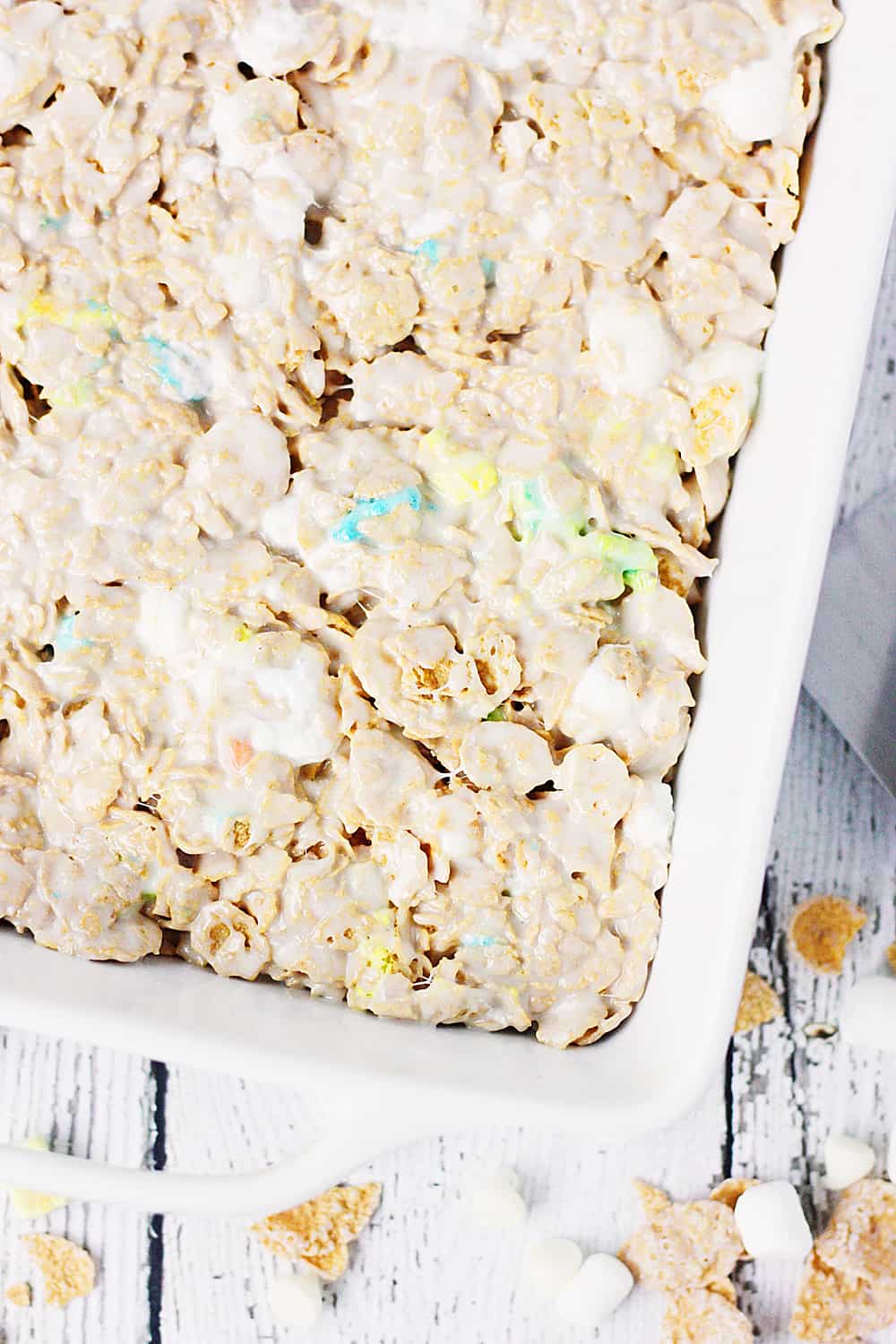 Lucky Charms Frosted Flakes Marshmallow Treats -- You'll think you've died and gone to heaven when you taste these Lucky Charms Frosted Flakes marshmallow treats. They're extra marshmallowy, buttery, and white chocolaty! | halfscratched.com