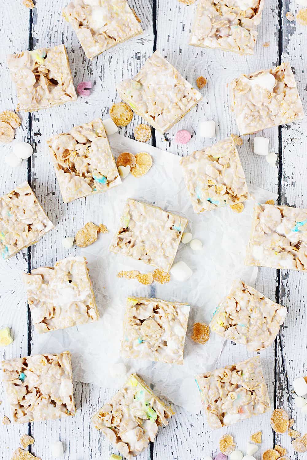 Lucky Charms Frosted Flakes Marshmallow Treats -- You'll think you've died and gone to heaven when you taste these Lucky Charms Frosted Flakes marshmallow treats. They're extra marshmallowy, buttery, and white chocolaty! | halfscratched.com