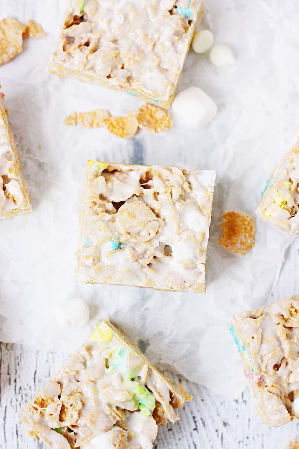 Lucky Charms Frosted Flakes Marshmallow Treats -- You'll think you've died and gone to heaven when you taste these Lucky Charms Frosted Flakes marshmallow treats. They're extra marshmallowy, buttery, and white chocolaty! | halfscratched.com
