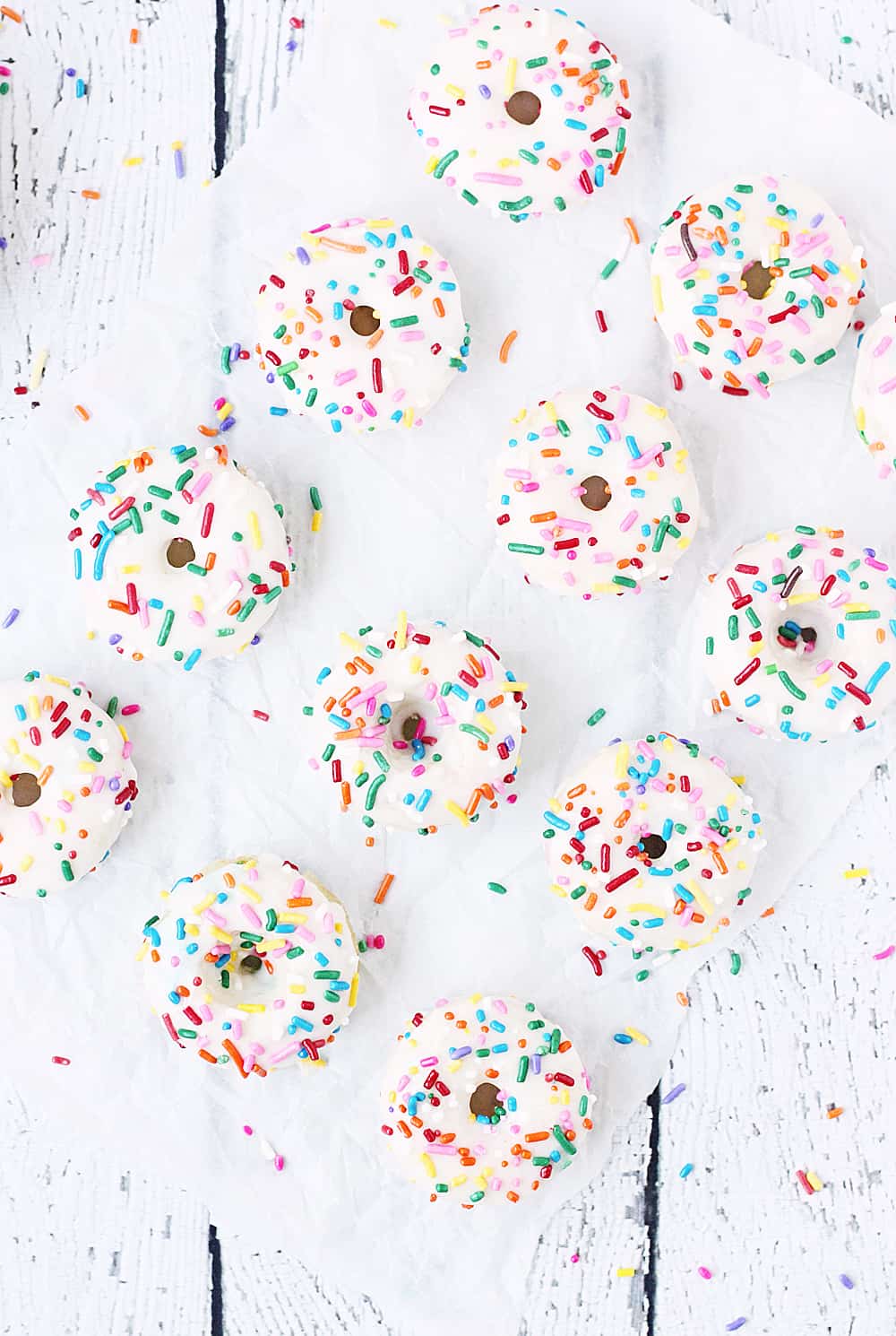 Mini Funfetti Cake Mix Donuts with Vanilla Glaze --Mini funfetti cake mix donuts are the perfect party treat! Topped with a vanilla glaze and colorful sprinkles, these mini donuts from cake mix are not only super cute but also super easy! #donuts #doughnut #cakemix #dessert #funfetti #bakeddonuts #recipe #dessert #cakemixrecipe 