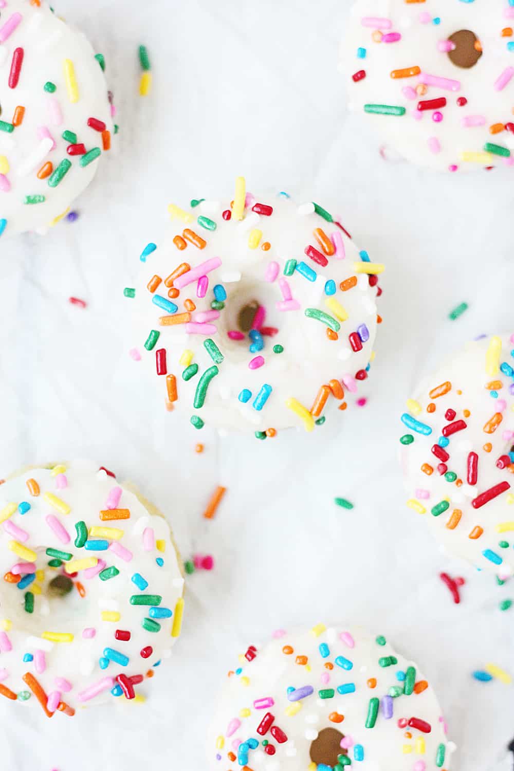 Mini Funfetti Cake Mix Donuts with Vanilla Glaze --Mini funfetti cake mix donuts are the perfect party treat! Topped with a vanilla glaze and colorful sprinkles, these mini donuts from cake mix are not only super cute but also super easy! #donuts #doughnut #cakemix #dessert #funfetti #bakeddonuts #recipe #dessert #cakemixrecipe 