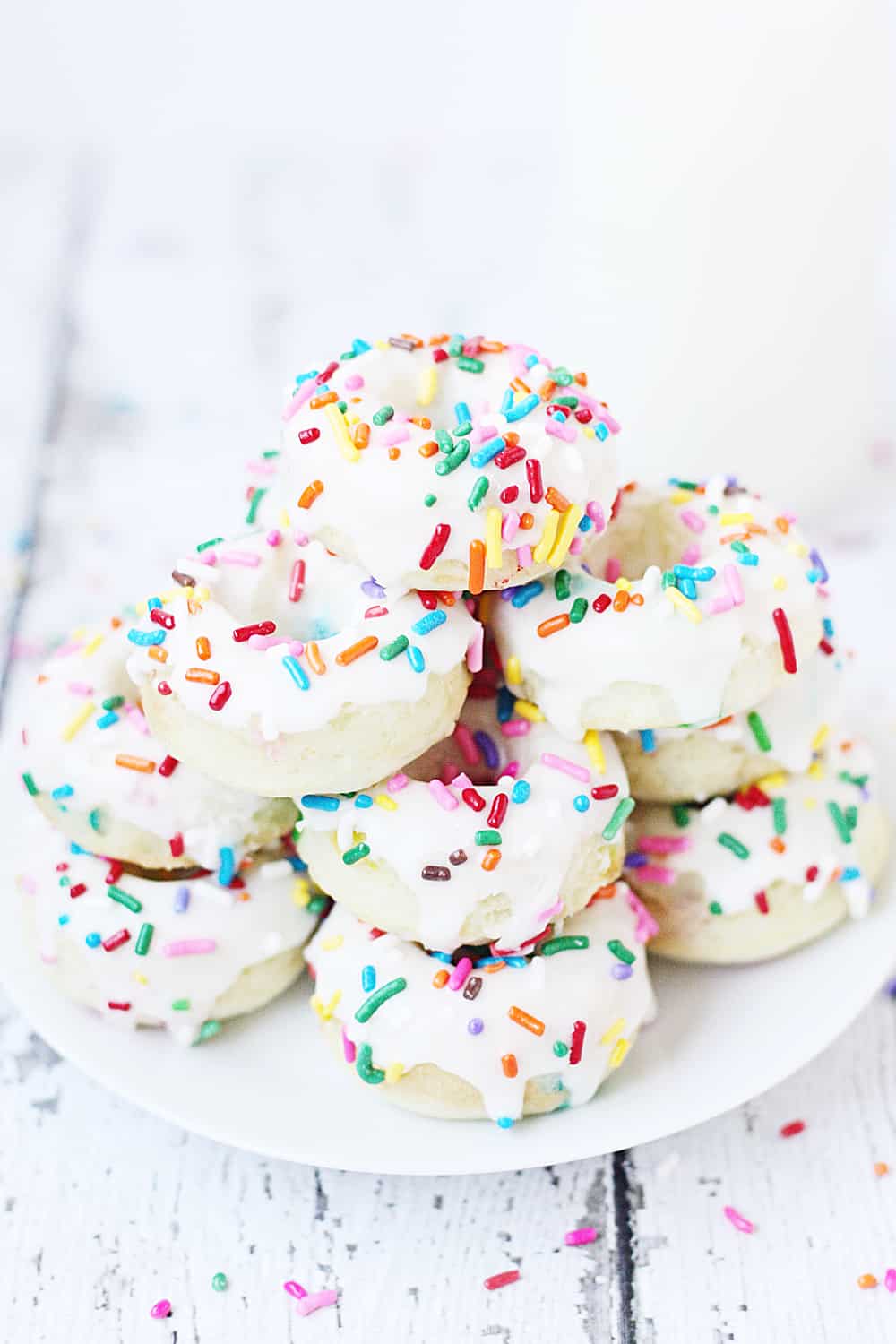 Mini Funfetti Cake Mix Donuts with Vanilla Glaze --Mini funfetti cake mix donuts are the perfect party treat! Topped with a vanilla glaze and colorful sprinkles, these mini donuts from cake mix are not only super cute but also super easy! #donuts #doughnut #cakemix #dessert #funfetti #bakeddonuts #recipe #dessert #cakemixrecipe 