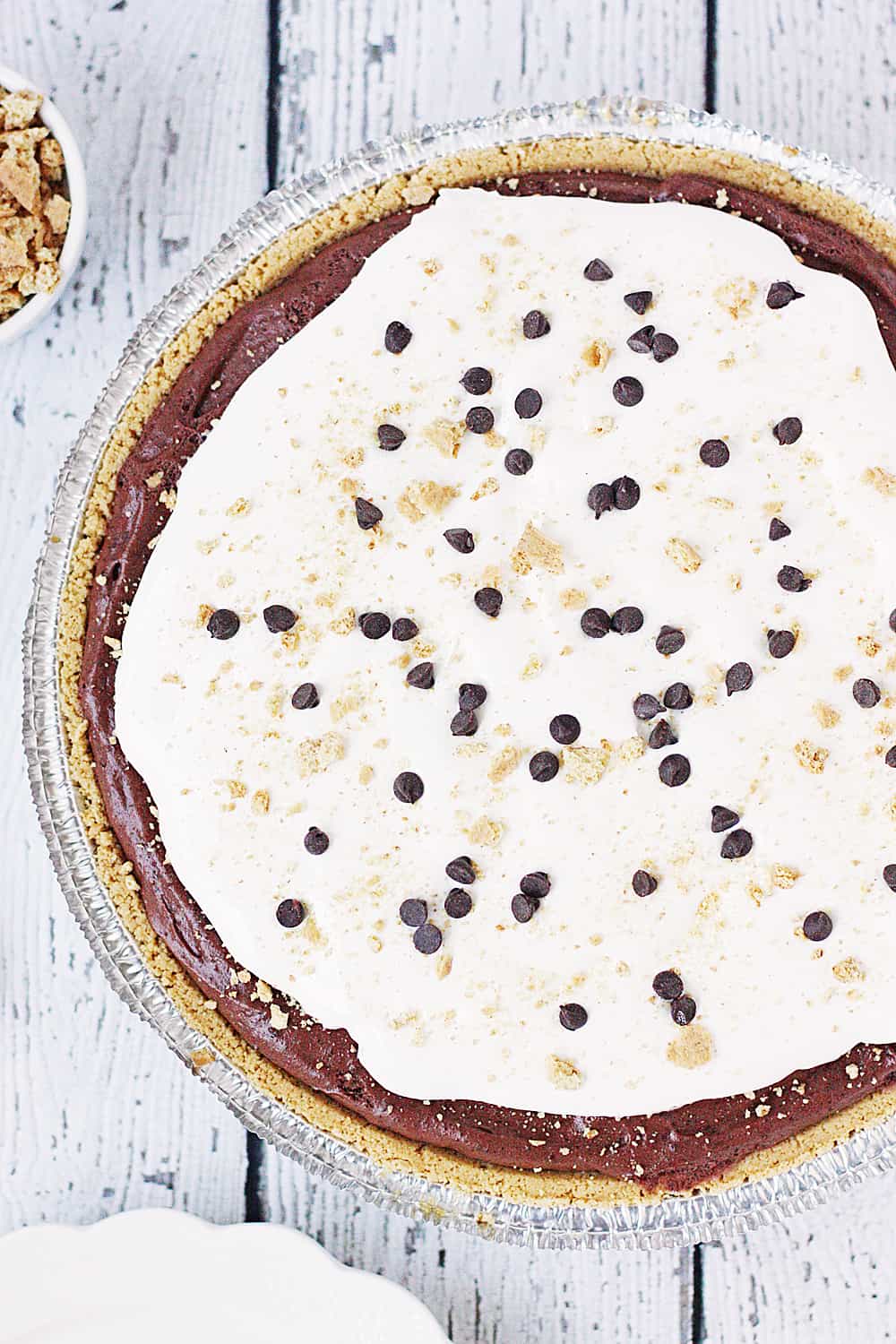 Smores Dream Pie -- This s'mores dream pie might not be the prettiest but it's definitely decadent--graham cracker pie crust, creamy chocolate fudge filling, marshmallow fluff, and a topping of crushed grahams and mini chocolate chips. | halfscratched