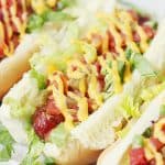 Spicy Bacon-Wrapped BLT Dogs -- Making bacon-wrapped hot dogs in the oven is easier than you think! Try this simple technique for bacon hot dogs as you throw together a batch of these spicy BLT dogs drizzled with melted cheese sauce. #halfscratched #hotdogs #blt #bacon #easyrecipe #maindish #bbq #barbecue #grilling
