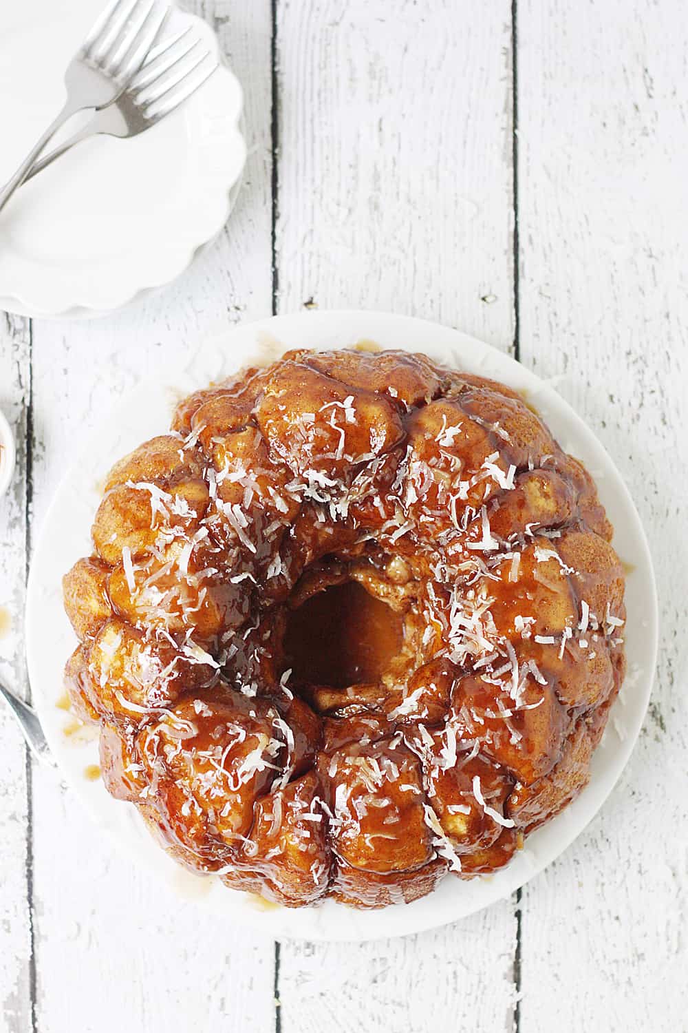 Easy Coconut Caramel Monkey Bread -- You'll want to lick every finger after eating this easy coconut caramel monkey bread! Pull-apart, cinnamon-coated bread is covered in gooey caramel sauce and sprinkled with sweet shredded coconut. It's to die for! #halfscratched #monkeybread #bread #dessert #easyrecipe #coconut #caramel