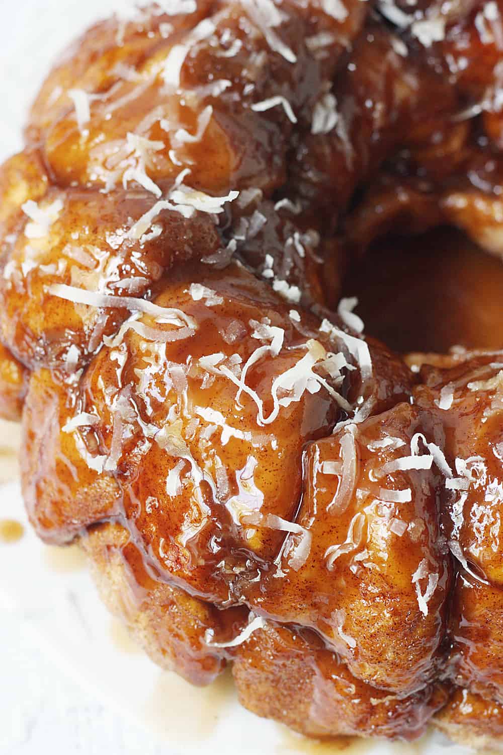 Easy Coconut Caramel Monkey Bread -- You'll want to lick every finger after eating this easy coconut caramel monkey bread! Pull-apart, cinnamon-coated bread is covered in gooey caramel sauce and sprinkled with sweet shredded coconut. It's to die for! #halfscratched #monkeybread #bread #dessert #easyrecipe #coconut #caramel