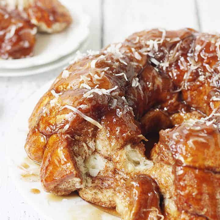 Easy Coconut Caramel Monkey Bread -- You'll want to lick every finger after eating this easy coconut caramel monkey bread! Pull-apart, cinnamon-coated bread is covered in gooey caramel sauce and sprinkled with sweet shredded coconut. It's to die for! #halfscratched #monkeybread #bread #dessert #easyrecipe #coconut #caramel