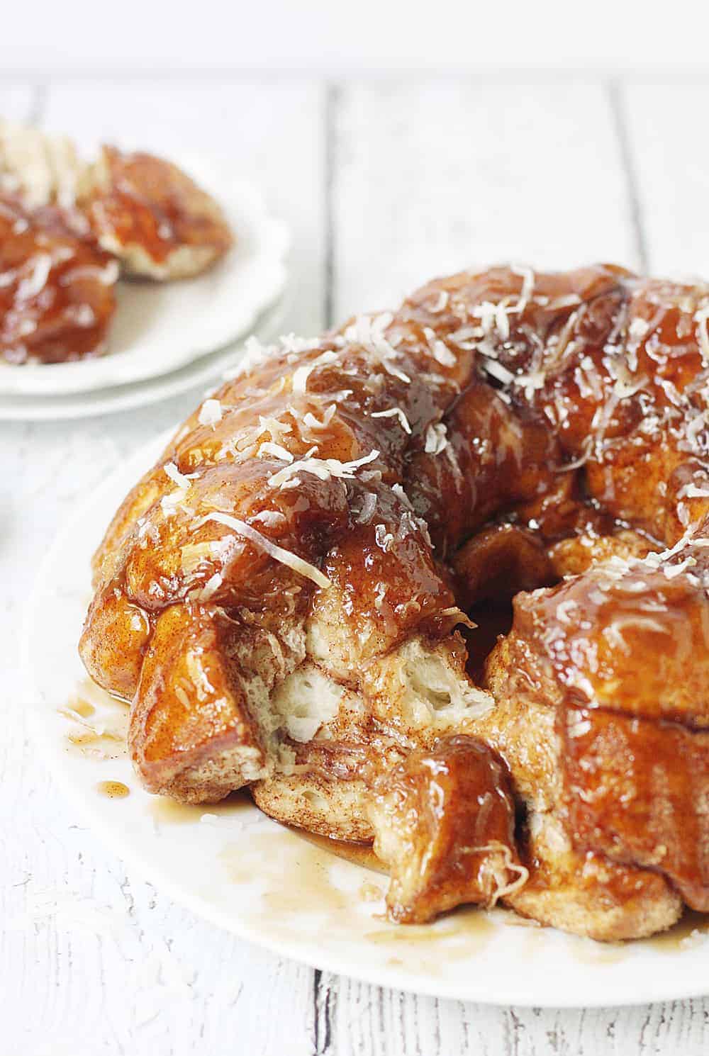 Easy Coconut Caramel Monkey Bread -- You'll want to lick every finger after eating this easy coconut caramel monkey bread! Pull-apart, cinnamon-coated bread is covered in gooey caramel sauce and sprinkled with sweet shredded coconut. It's to die for! #halfscratched #monkeybread #bread #dessert #easyrecipe #coconut #caramel