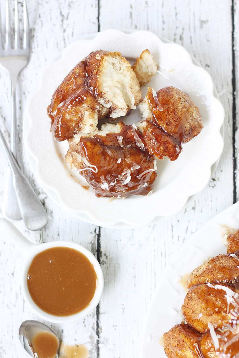 Easy Coconut Caramel Monkey Bread -- You'll want to lick every finger after eating this easy coconut caramel monkey bread! Pull-apart, cinnamon-coated bread is covered in gooey caramel sauce and sprinkled with sweet shredded coconut. It's to die for! #halfscratched #monkeybread #bread #dessert #easyrecipe #coconut #caramel