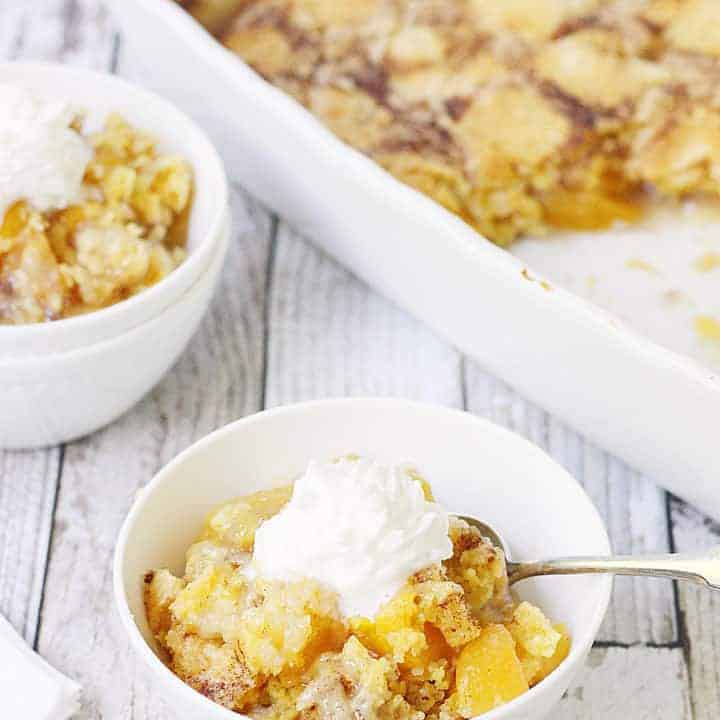 Easy Peach Cobbler Dump Cake -- Easy peach cobbler dump cake is sure to become a summer staple! This mouthwatering peach cobbler recipe requires only four ingredients and five minutes of prep! #cake #peachcobbler #dumpcake #dessert #easyrecipe #cakemix #cobbler #peach