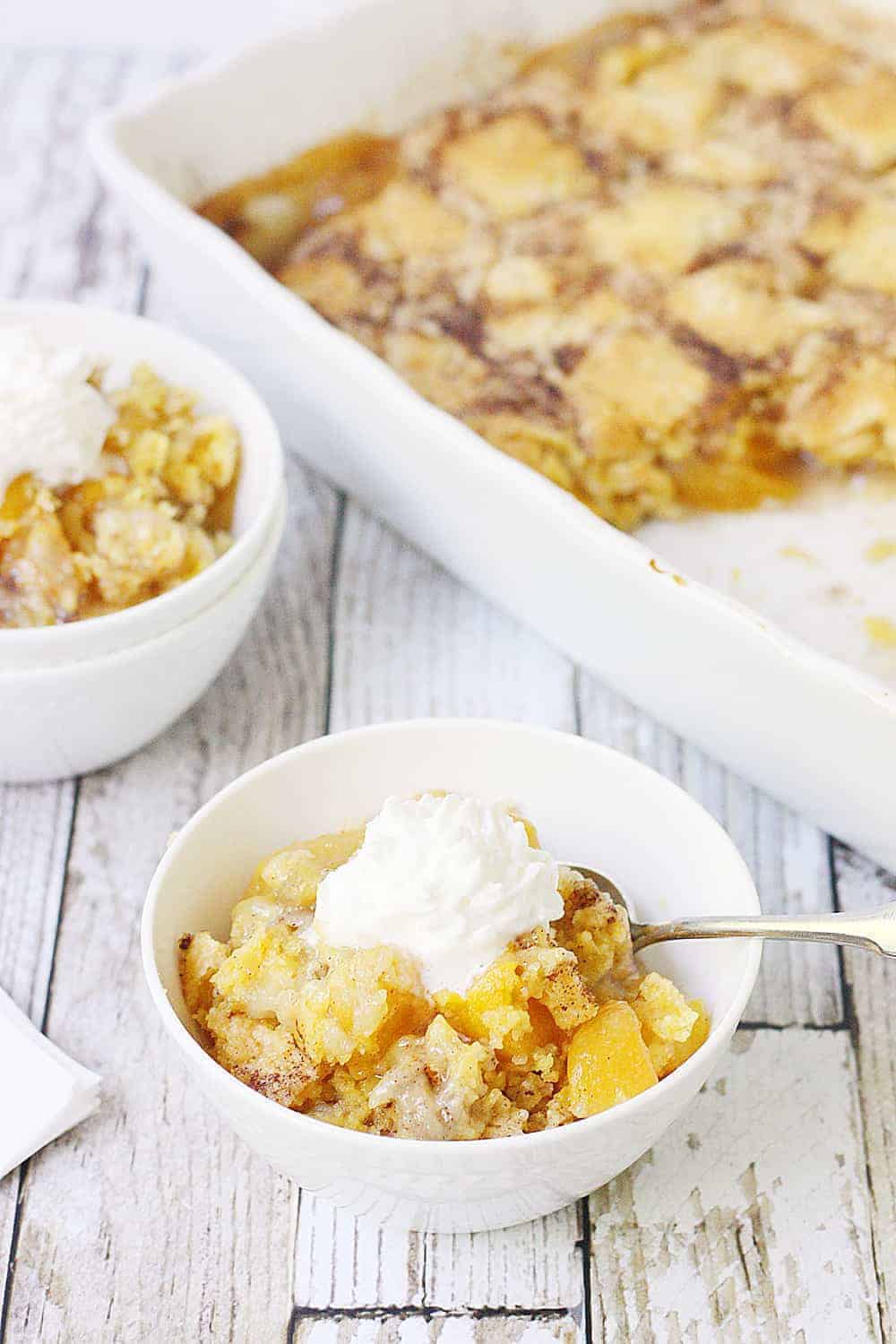 Easy Peach Cobbler Dump Cake -- Easy peach cobbler dump cake is sure to become a summer staple! This mouthwatering peach cobbler recipe requires only four ingredients and five minutes of prep! #cake #peachcobbler #dumpcake #dessert #easyrecipe #cakemix #cobbler #peach