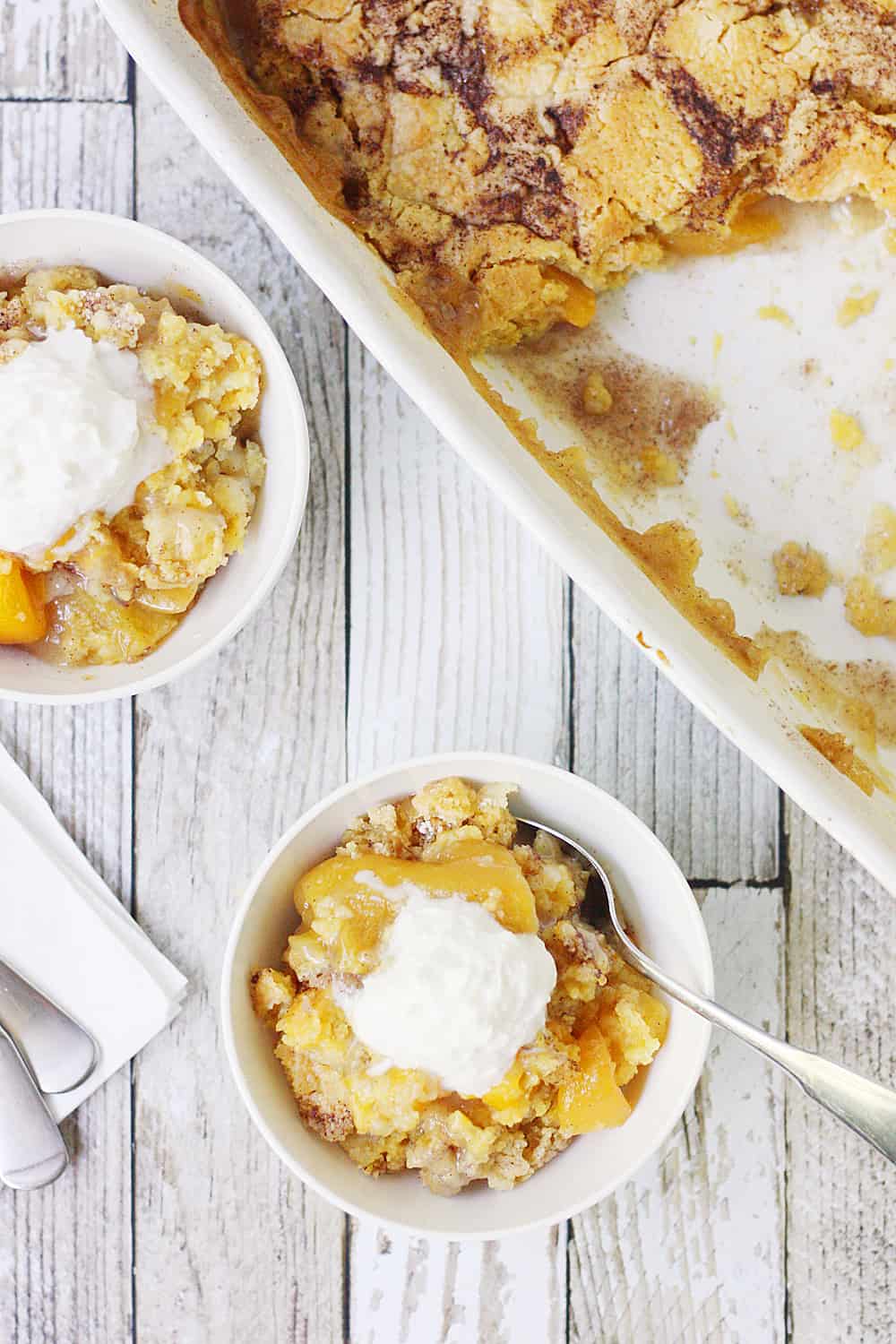 Easy Peach Cobbler Dump Cake -- Easy peach cobbler dump cake is sure to become a summer staple! This mouthwatering peach cobbler recipe requires only four ingredients and five minutes of prep! #cake #peachcobbler #dumpcake #dessert #easyrecipe #cakemix #cobbler #peach
