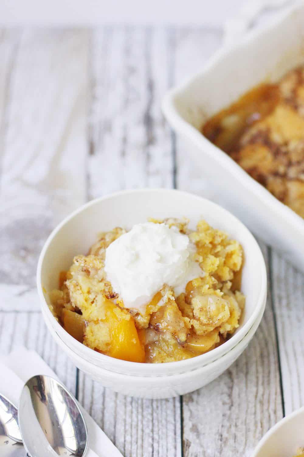 Easy Peach Cobbler Dump Cake -- Easy peach cobbler dump cake is sure to become a summer staple! This mouthwatering peach cobbler recipe requires only four ingredients and five minutes of prep! #cake #peachcobbler #dumpcake #dessert #easyrecipe #cakemix #cobbler #peach