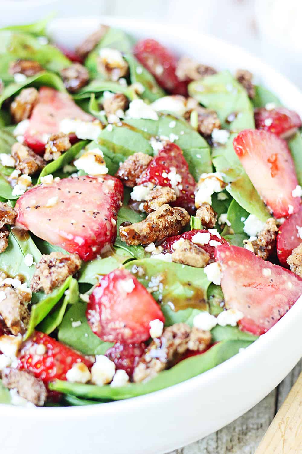 Strawberry Spinach Salad with Balsamic Poppy Seed Dressing -- This strawberry spinach salad boasts baby spinach, fresh strawberries, candied pecans, feta cheese, and the most amazing balsamic poppy seed dressing!