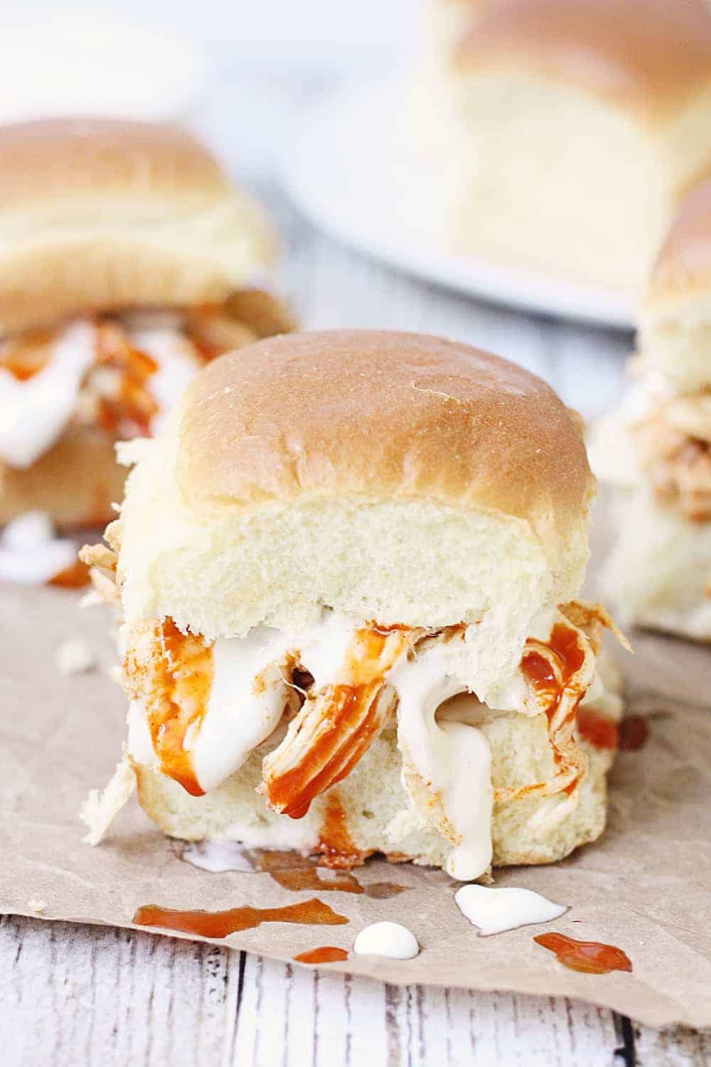 Slow Cooker Buffalo Ranch Chicken -- This slow cooker buffalo ranch chicken makes THE BEST sliders. Top with creamy blue cheese dressing and pepper jack cheese for the perfect party sandwich! #halfscratched #buffalochicken #sliders #sandwich #buffaloranch #slowcooker #crockpot #recipe #appetizer #chickensliders #chickensandwich #cooking #easyrecipe