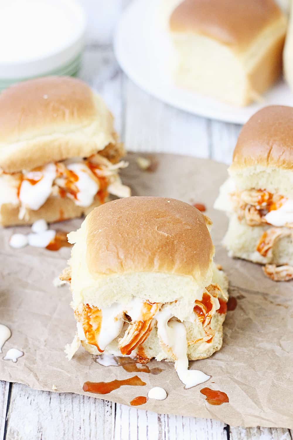 Slow Cooker Buffalo Ranch Chicken -- This slow cooker buffalo ranch chicken makes THE BEST sliders. Top with creamy blue cheese dressing and pepper jack cheese for the perfect party sandwich! #halfscratched #buffalochicken #sliders #sandwich #buffaloranch #slowcooker #crockpot #recipe #appetizer #chickensliders #chickensandwich #cooking #easyrecipe