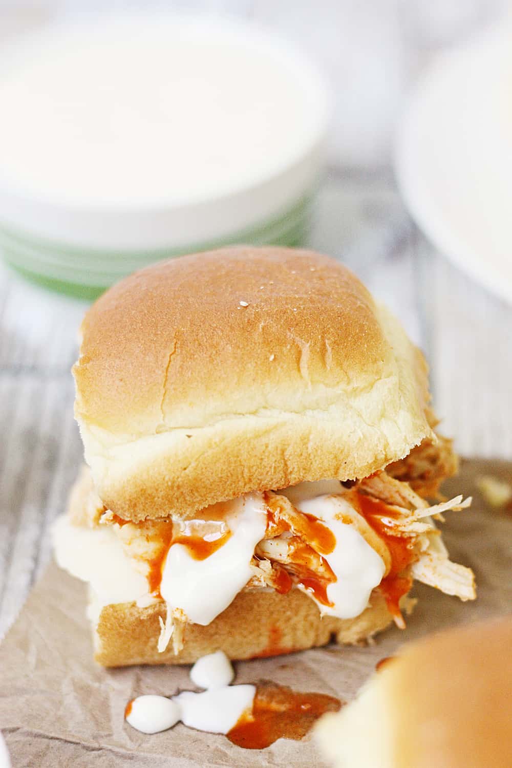 Slow Cooker Buffalo Ranch Chicken -- This slow cooker buffalo ranch chicken makes THE BEST sliders. Top with creamy blue cheese dressing and pepper jack cheese for the perfect party sandwich! #halfscratched #buffalochicken #sliders #sandwich #buffaloranch #slowcooker #crockpot #recipe #appetizer #chickensliders #chickensandwich #cooking #easyrecipe