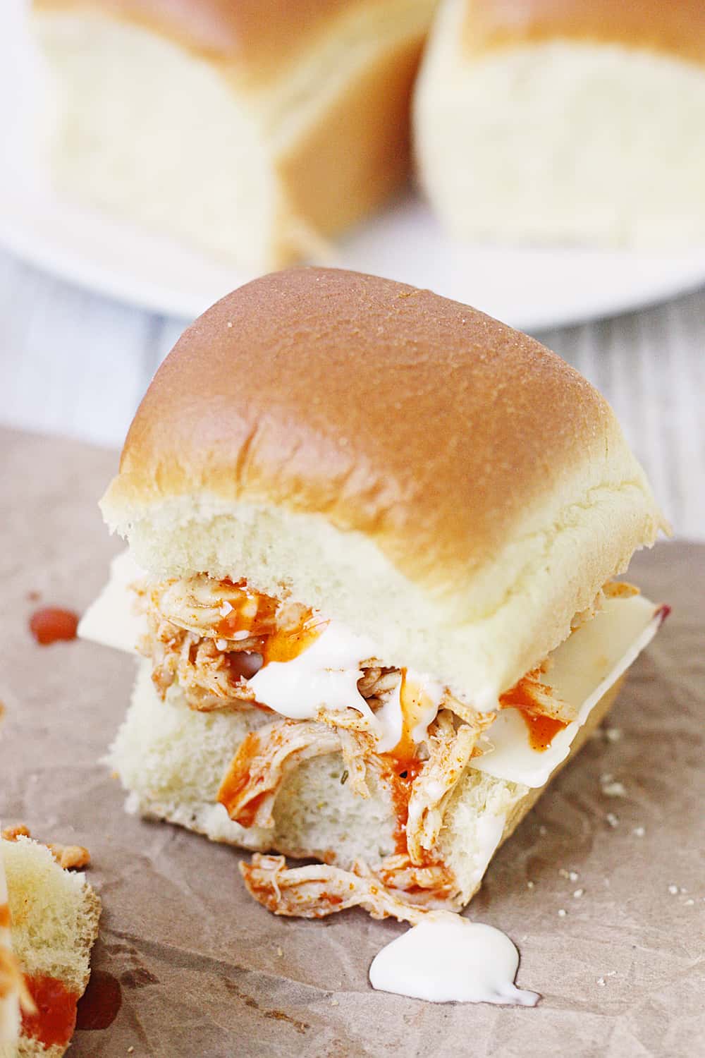 Slow Cooker Buffalo Ranch Chicken -- This slow cooker buffalo ranch chicken makes THE BEST sliders. Top with creamy blue cheese dressing and pepper jack cheese for the perfect party sandwich! #halfscratched #buffalochicken #sliders #sandwich #buffaloranch #slowcooker #crockpot #recipe #appetizer #chickensliders #chickensandwich #cooking #easyrecipe