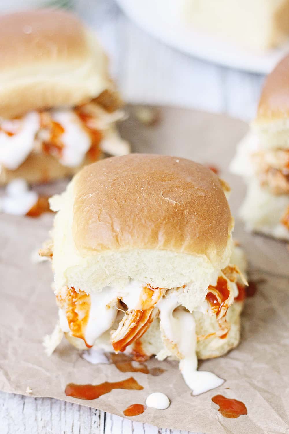 Slow Cooker Buffalo Ranch Chicken -- This slow cooker buffalo ranch chicken makes THE BEST sliders. Top with creamy blue cheese dressing and pepper jack cheese for the perfect party sandwich! #halfscratched #buffalochicken #sliders #sandwich #buffaloranch #slowcooker #crockpot #recipe #appetizer #chickensliders #chickensandwich #cooking #easyrecipe