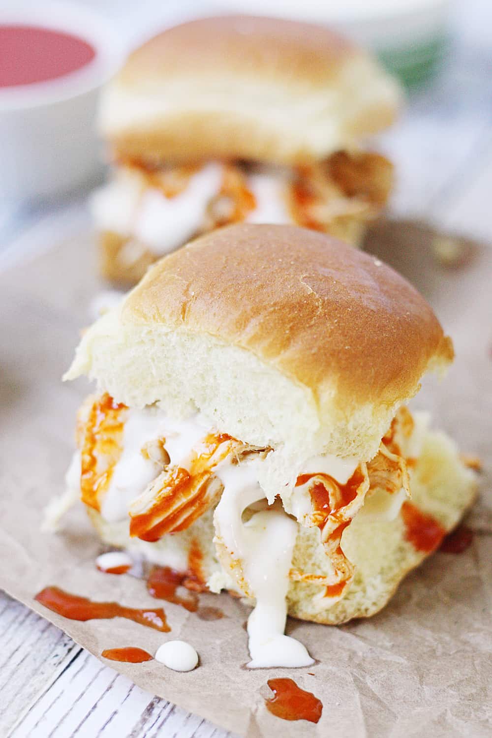 Slow Cooker Buffalo Ranch Chicken -- This slow cooker buffalo ranch chicken makes THE BEST sliders. Top with creamy blue cheese dressing and pepper jack cheese for the perfect party sandwich! #halfscratched #buffalochicken #sliders #sandwich #buffaloranch #slowcooker #crockpot #recipe #appetizer #chickensliders #chickensandwich #cooking #easyrecipe