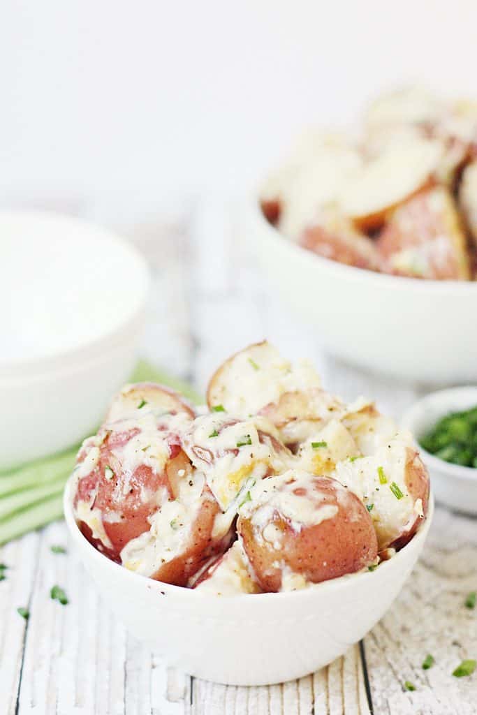 Crock Pot Ranch Potatoes -- Crock pot ranch potatoes will become your new favorite recipe! Throw potatoes, ranch dressing, some cheese and seasonings into a crock pot and in a few hours you have a creamy, savory side dish the entire family will love! #crockpot #slowcooker #potatoes #crockpotpotatoes #slowcookerpotatoes #ranchpotatoes #halfscratched #easyrecipe #sidedish #holidayrecipe #ranchdressing #cooking #baking