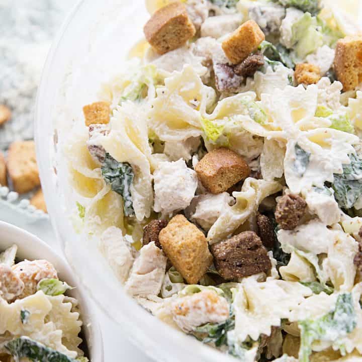 Best Bowtie Chicken Caesar Salad - There's chicken Caesar salad and there's chicken Caesar pasta salad. Once you add bowtie pasta to Caesar salad, you won't want to eat it any other way! #caesarsalad #bowtie #pastasalad #pasta #salad #halfscratched #easyrecipe #sidedish