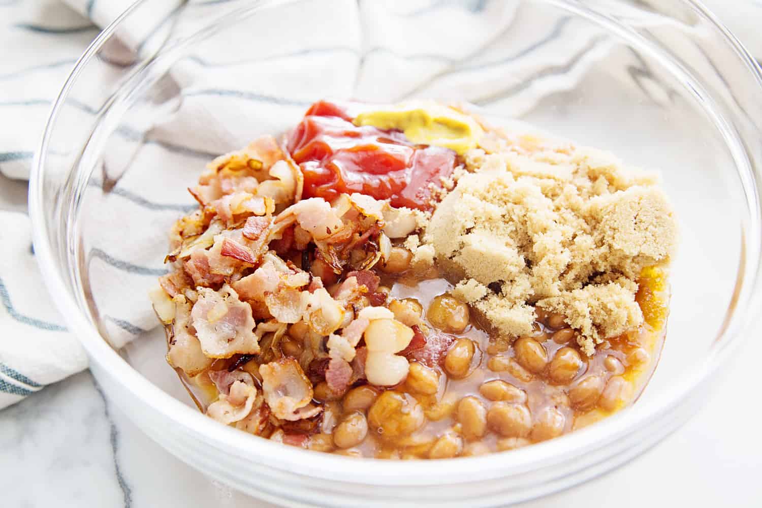 Homemade Baked Beans -- Looking for the best homemade baked beans recipe? This is it! A handful of ingredients plus a half hour in the oven equals the yummiest, most crowd-pleasing baked beans from scratch! #halfscratched #bakedbeans #beans #sidedish #savory #bacon #lentils #easyrecipe