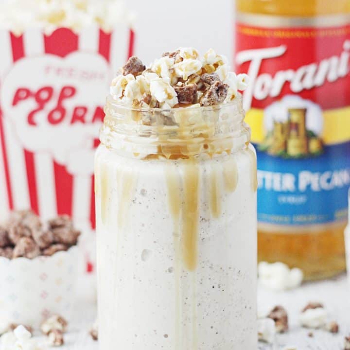 Take your stay-at-home movie nights up a notch with a kettle corn butter pecan shake! Vanilla ice cream, butter pecan syrup, and candied pecans are blended together and topped with kettle corn, more candied pecans, and a drizzle of caramel syrup. #FallforFlavor #Torani #halfscratched #butterpecan #kettlecorn #milkshake #dessert #dessertrecipe #shakerecipe #movietreat #treats #frozentreats #icecream #ad