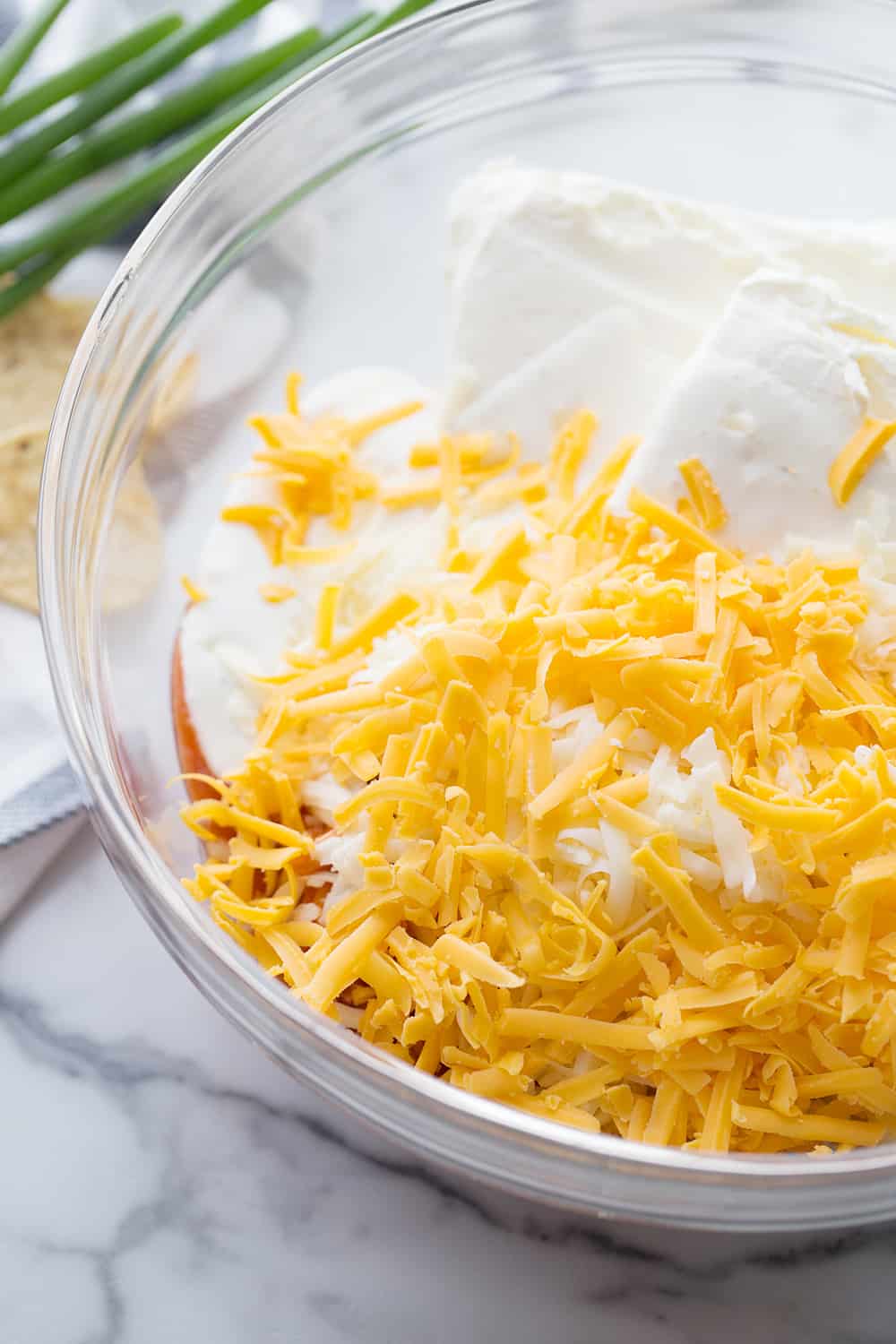 Buffalo Chicken Dip ingredients in a glass bowl.