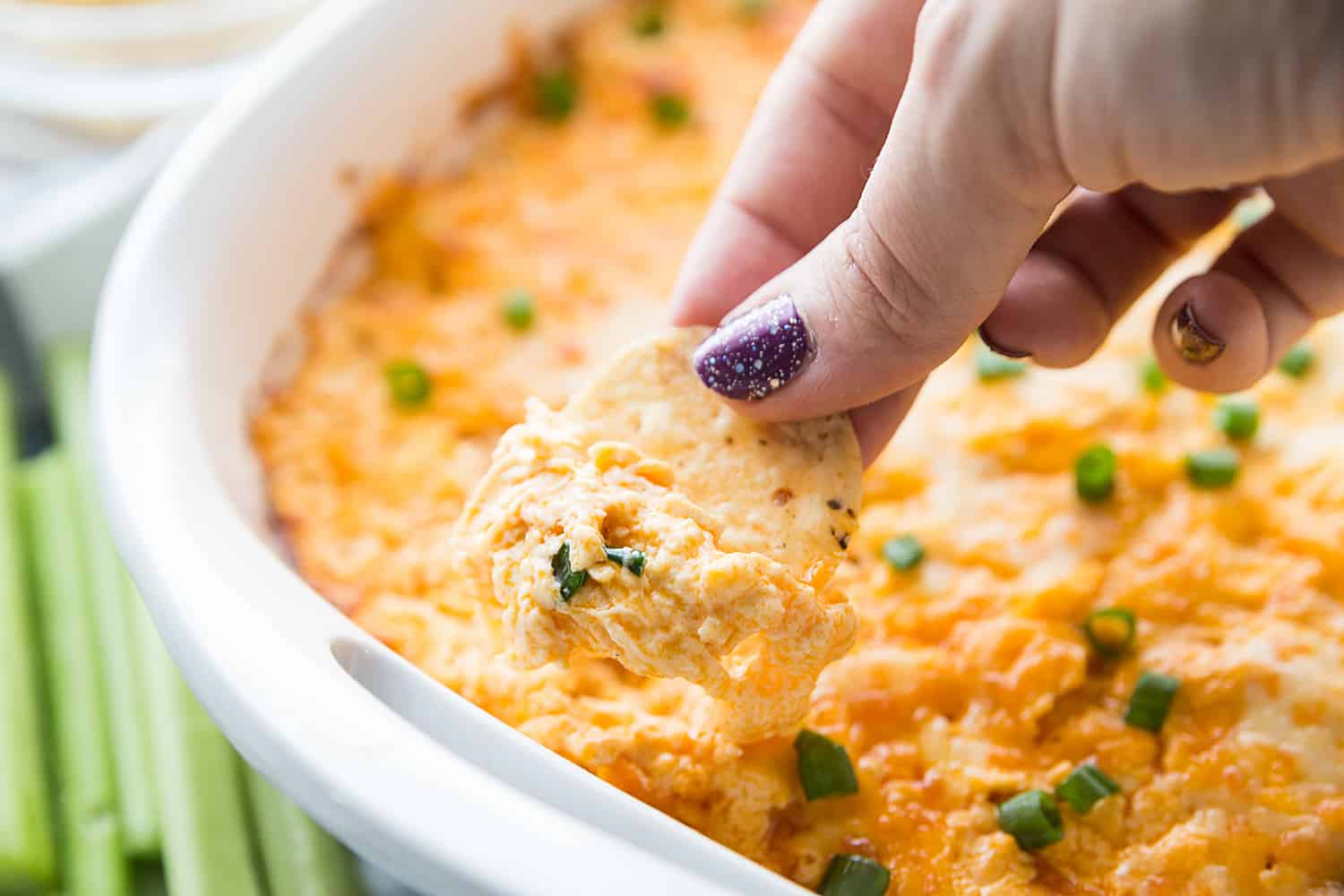 Dipping a chip in a Buffalo Chicken Dip.