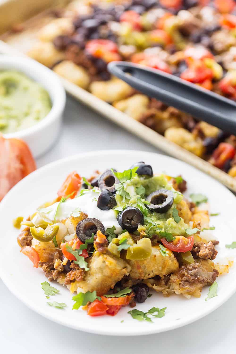 Tater Tot Nachos (Totchos) - What's better than crispy, crunch tater tots topped with oh-so-flavorful nacho fixings? Nothing! That's why tater tot nachos, aka totchos, are always a hit! #nachos #tatertots #tatertotcasserole #appetizer #baking #cooking #easyrecipe #halfscratched #tatertotnachos #mexicanfood