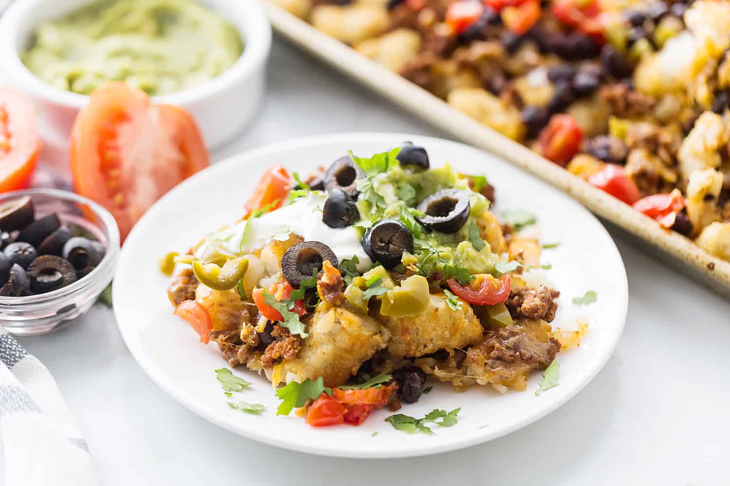 Tater Tot Nachos (Totchos) - What's better than crispy, crunch tater tots topped with oh-so-flavorful nacho fixings? Nothing! That's why tater tot nachos, aka totchos, are always a hit! #nachos #tatertots #tatertotcasserole #appetizer #baking #cooking #easyrecipe #halfscratched #tatertotnachos #mexicanfood