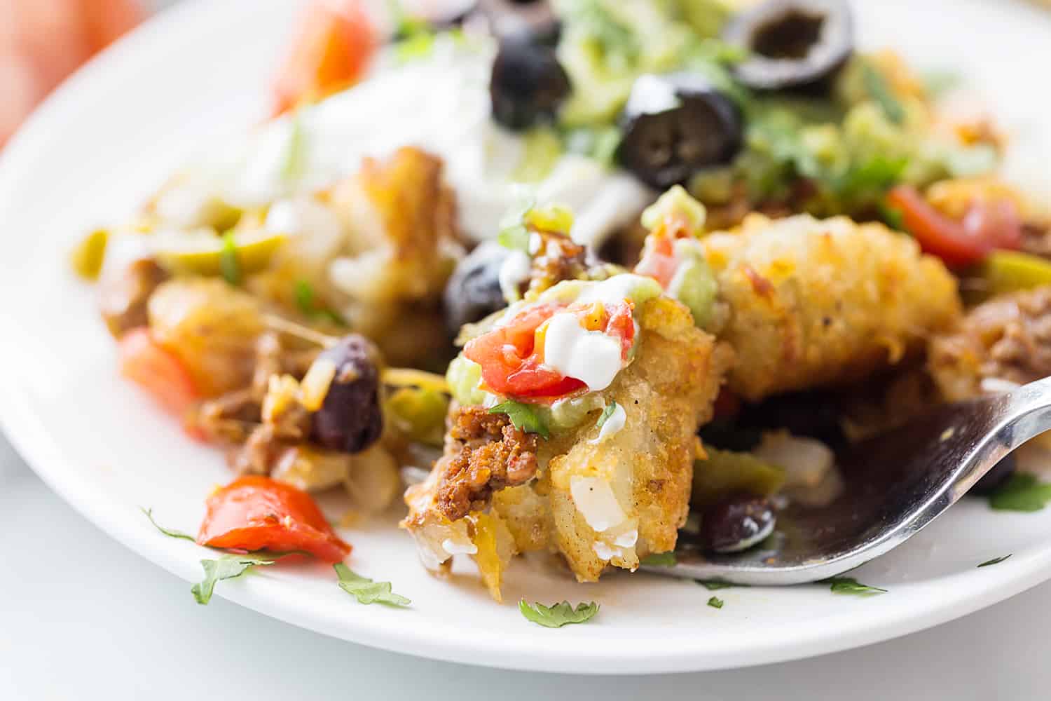 Tater Tot Nachos (Totchos) - What's better than crispy, crunch tater tots topped with oh-so-flavorful nacho fixings? Nothing! That's why tater tot nachos, aka totchos, are always a hit! #nachos #tatertots #tatertotcasserole #appetizer #baking #cooking #easyrecipe #halfscratched #tatertotnachos #mexicanfood